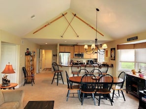 A spacious kitchen with a central island, wooden chairs, and a dining table. - Fv23 Awesome on Golf Course in Bretton Woods With Mountain Views (Bretton Woods)