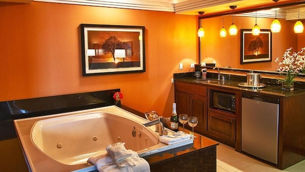 Une salle de bain moderne avec une grande baignoire, un meuble-lavabo et un miroir au-dessus du lavabo.