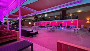 Un vaste espace extérieur doté de plusieurs coins salon, d’une piscine et d’une partie abritée avec une rambarde.