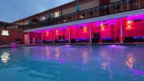 Un hôtel doté d’une piscine, d’un espace extérieur aménagé et de balcons équipés de parasols.