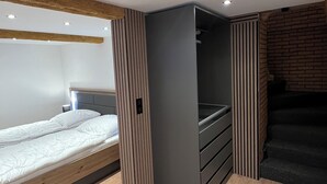 Een moderne slaapkamer met een bed, inbouwkast en een trap.