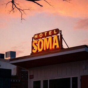 A hotel sign with the name 'HOTEL SOMA' illuminated against a sunset sky. - Hotel SOMA (Fort Worth)