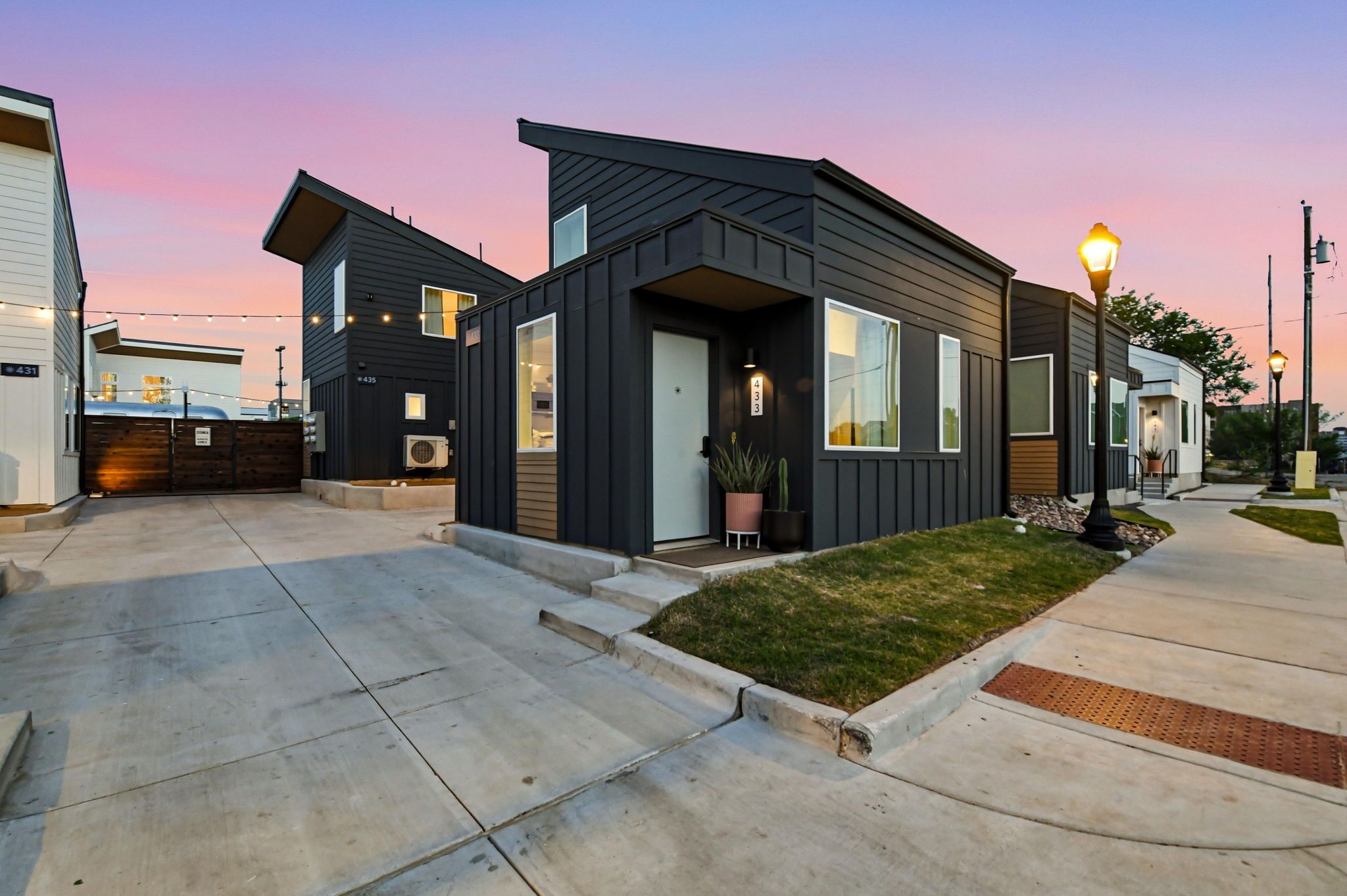 A modern residential area with houses featuring dark siding and large windows.