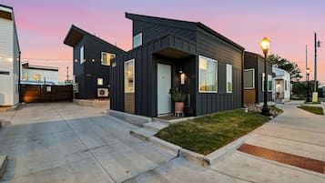 A modern residential area with houses featuring dark siding and large windows.