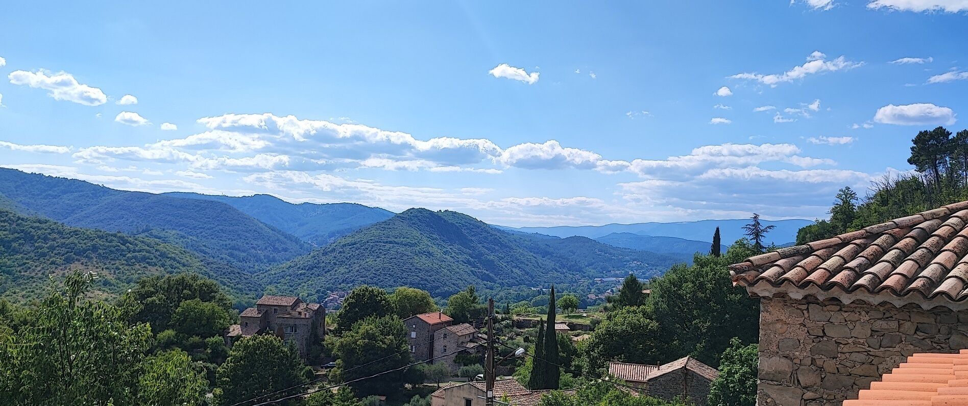 A mountainous landscape with traditional stone buildings and terracotta roofs.