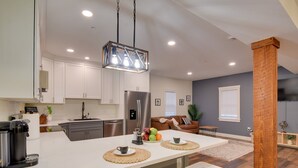 A modern kitchen with white cabinets, a stainless steel refrigerator, and a central island with a coffee machine and fruit. - Walk to Lititz Springs Park: Cozy Getaway! Apt 2 (Lititz)