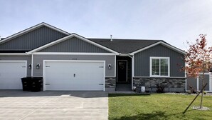 A two-story house with a garage, a front door, and a small tree in the yard. - Hazen Home. Family Retreat. Fully equipped home. 2 min to shopping and parks. (Ammon)