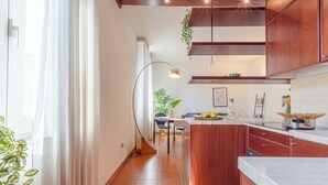 Cozinha moderna com armários de madeira, uma ilha central e uma área de refeições com mesa e cadeiras.