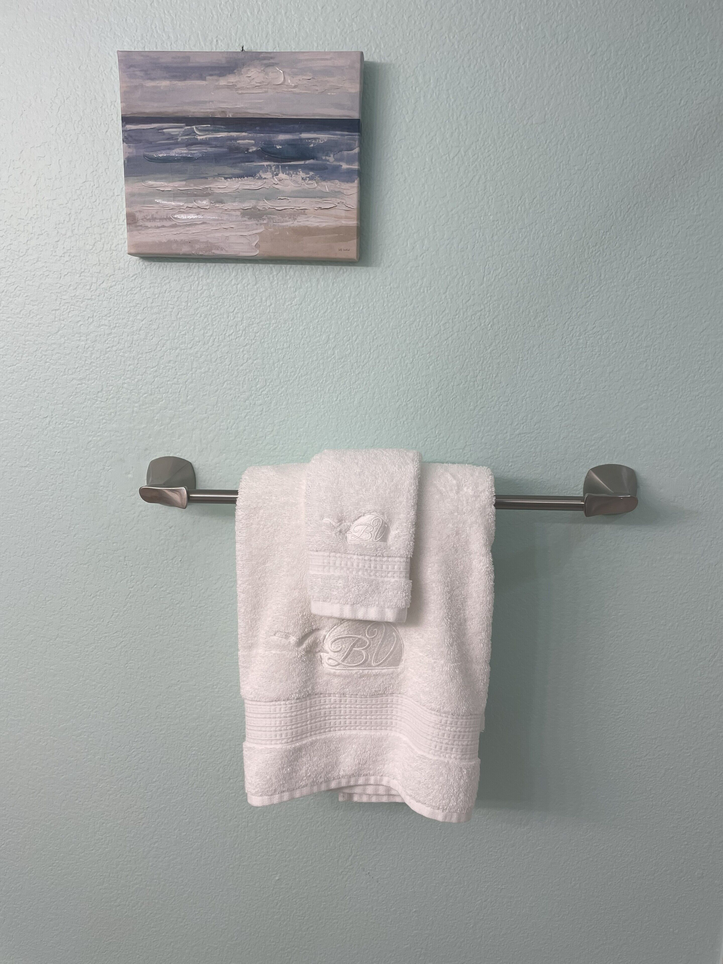 A bathroom with a towel rack holding a folded white towel.