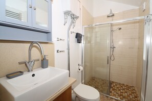 Regadera, secadora de cabello, toallas, papel de baño 