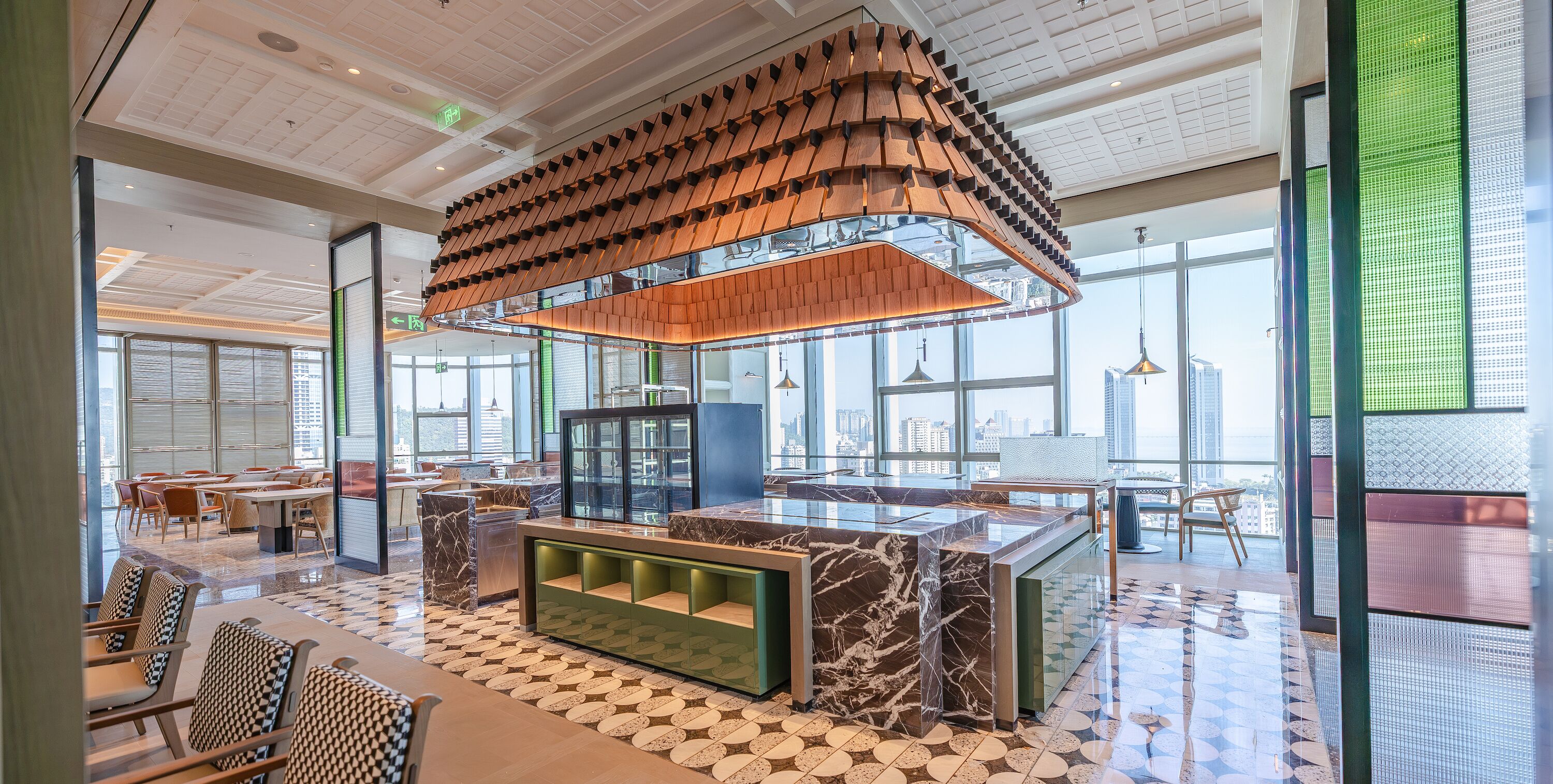 A modern interior with a central seating area, a high ceiling with a unique wooden design, and large windows offering views of the city.
