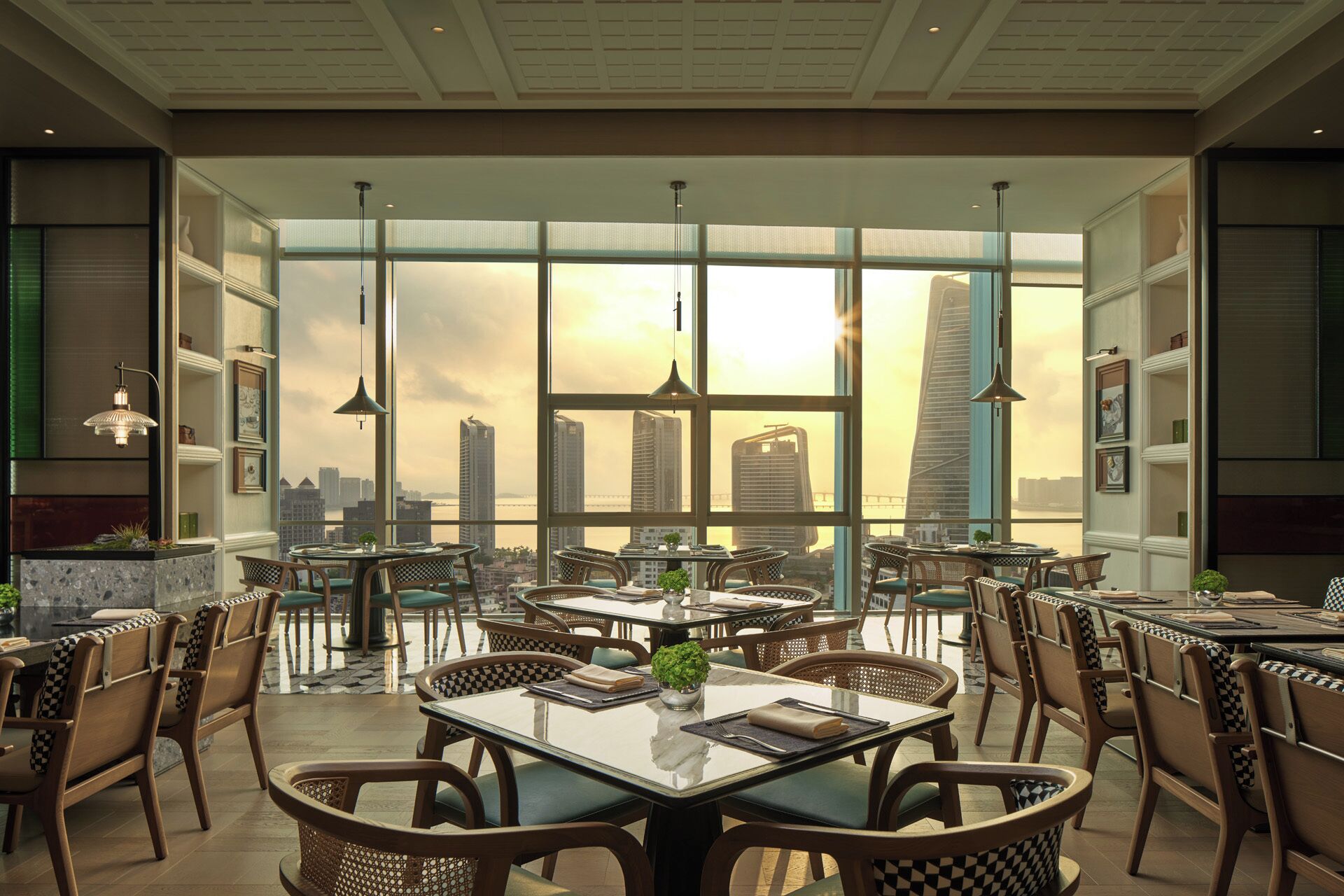 An indoor dining area with tables and chairs, large windows with a city view, and pendant lighting.