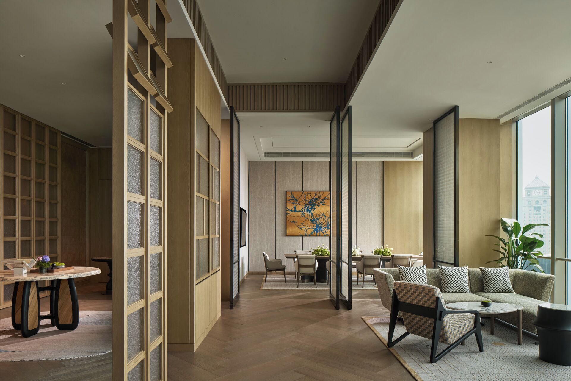 Een modern interieur met een eethoek, zitplaatsen en een groot raam.