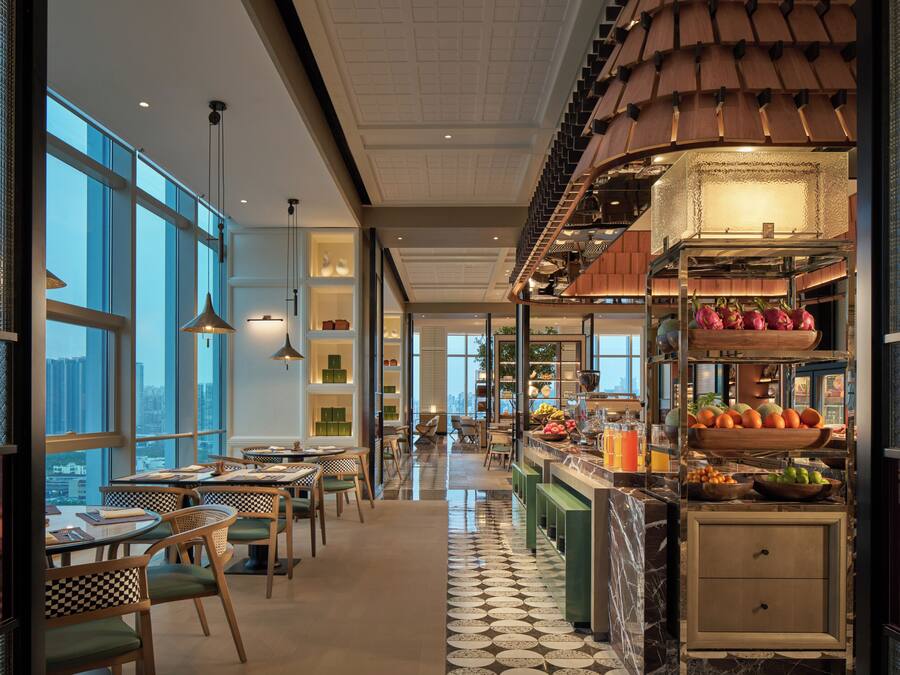 Un interior moderno con comedor, cocina y ventanas amplias que ofrecen vistas a la ciudad.