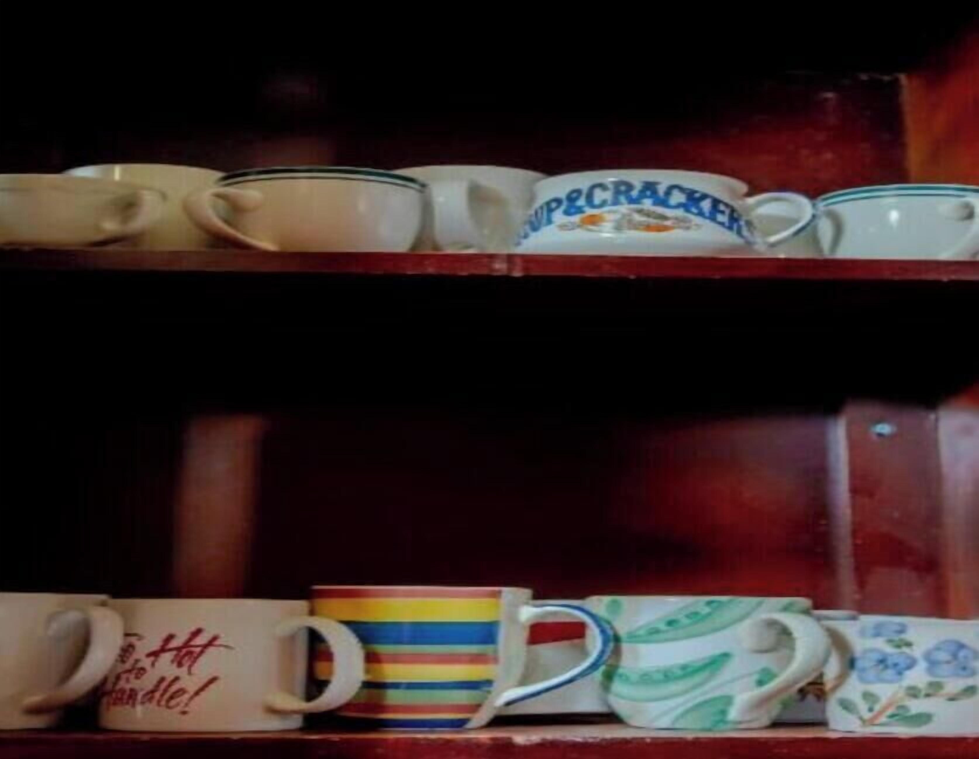 A shelf with various mugs and teacups.