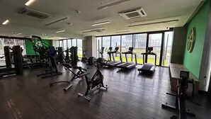 A gym with various exercise equipment, large windows, and a view of the outdoors. - Chic 3BR Prime Spot - 12 guests (Monterrey)
