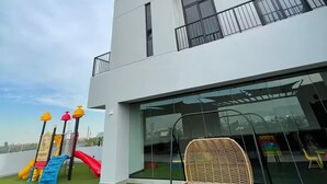 A modern building with multiple balconies and a children's play area with slides and climbing structures. - Chic 3BR Prime Spot - 12 guests (Monterrey)