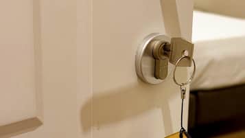 A door with a key lock and a keychain with a house-shaped keychain labeled "GIOIA GUEST HOUSE PIAZZA NAVONA".