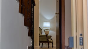 A marble staircase leading to a room with a lamp and chair.