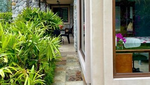 A modern building with a stone facade, a tiled pathway, and lush greenery. - Peaceful 2-bedroom, 2 bath  apartment in Boquete with vista to Baru (Boquete)