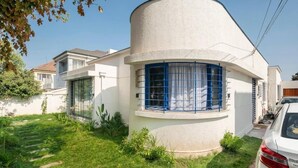 Une maison moderne au design original, caractérisée par des lignes courbes, une porte de garage bien visible et une pelouse parfaitement entretenue.