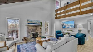 A spacious living room with a fireplace, a television, and a balcony. - Walk to Slopes-Mountain Views-Firepit-Sleeps 10 (Beech Mountain)