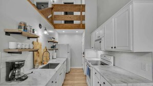 A modern kitchen with white cabinetry, wooden flooring, and a central island. - Walk to Slopes-Mountain Views-Firepit-Sleeps 10 (Beech Mountain)