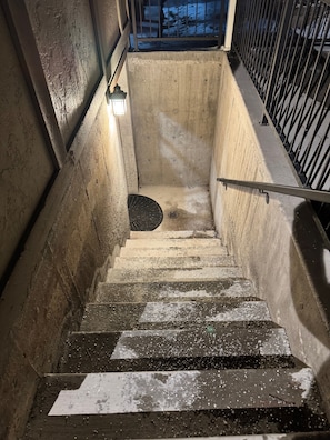 A concrete stairwell with metal railings and a handrail.