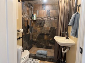 Une salle de bain moderne équipée d’une douche, de toilettes et d’un lavabo.
