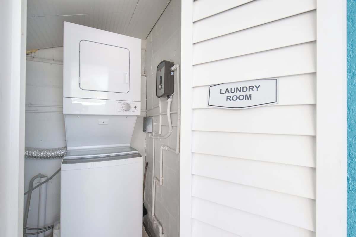 Una sala de lavandería con lavadora, secadora y un cartel que dice "LAUNDRY ROOM".