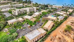 Vista aerea di una località balneare con numerosi edifici, parcheggi e una spiaggia.