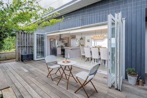 Ett modernt hus med en veranda, ett kök och en matplats.