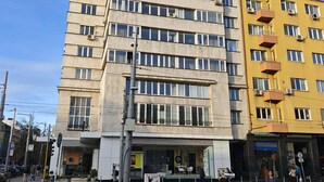 A multi-story building with a flat facade, large windows, and a pedestrian area in front. - Serdica Tower View DT Parking Wi-Fi AC (Sofia)