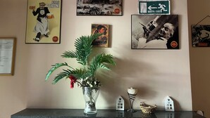 A wall with various posters, a potted plant, and a shelf with small house-shaped objects. - ciak Beb Cinecittà a 10 minutes to Rome centre (Roma)
