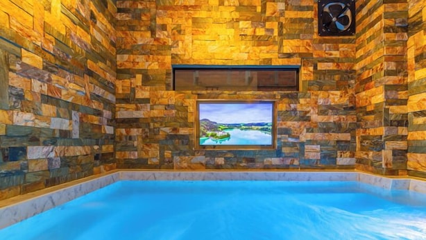 A spa room with a stone wall and a large window overlooking a scenic landscape. - 6BR w Jacuzzi  Private Baths Lleras (Medellín)