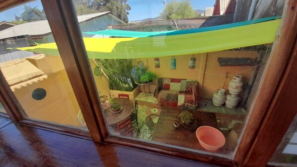 A small, enclosed outdoor space with a table, chairs, a patterned sofa, and a potted plant. - House for 12 people minutes from the beach (Coquimbo)