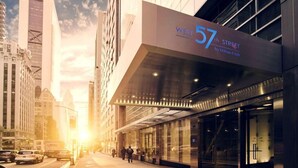 Una entrada de hotel moderna con un llamativo letrero que dice 'West 57th Street by Hilton Club'.