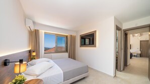 A modern hotel room with a bed, bedside lamps, a potted plant, a window with a view, and a small table. - A new built,  fully equipped residence - 5 min from Myrtos beach and Agia Efimia (Makriotika)