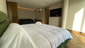 Una camera d'albergo con un letto grande, una televisione, una scrivania e una sedia.