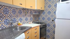A compact kitchen with a washing machine, a stove, and a sink. - PRAIA DA ROCHA - ATLANTICO IV (Portimão)
