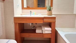 A bathroom with a wooden vanity, a sink, a mirror, a towel rack, and a bathtub. - PRAIA DA ROCHA- CASA DA PRAIA 904 (Portimão)