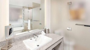 A modern bathroom with a white sink, granite countertop, and a large mirror. - Midtown 1BR at Hilton Club West 57th – Steps to Central Park & Fifth Ave (New York)