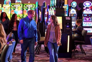 Un casino con máquinas tragamonedas y mesas de juego.