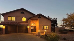 Una casa a due piani con garage, portico e vialetto.