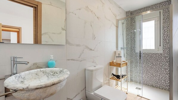 A bathroom with a marble sink, a toilet, and a shower area with a glass door. - Casa Rural Las Flores Nigüelas by Ruralidays (Granada)
