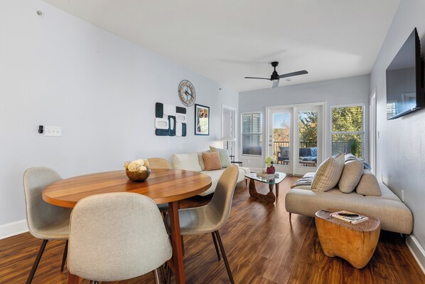 Un salón moderno con una mesa de comedor de madera, sofás color beige y una mesa de centro de vidrio.
