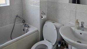 A bathroom with a bathtub, toilet, and sink. - Garden - Pets - Parking - Wifi - Sleeps 2 (Ashford)