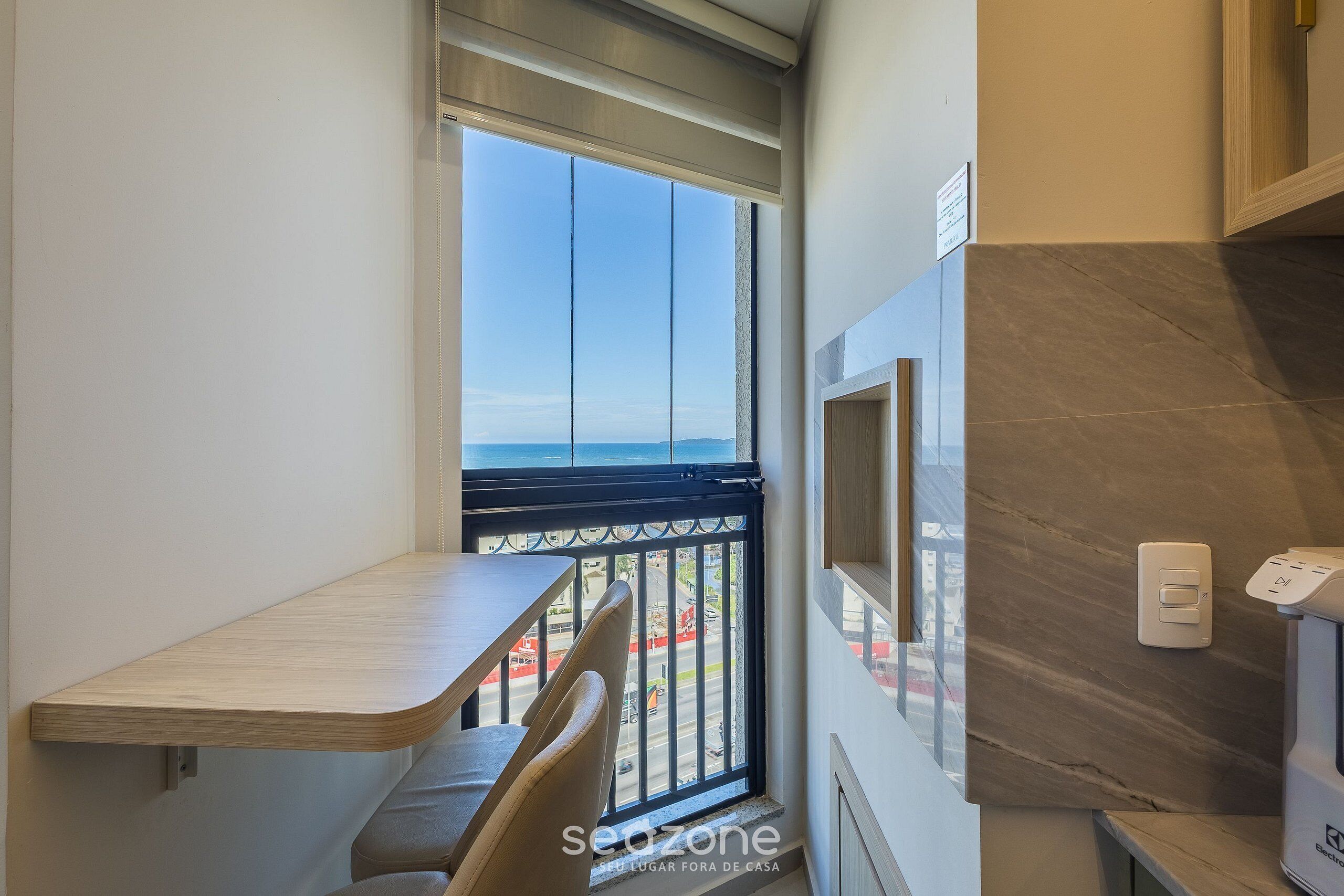 Un balcón con vistas a la ciudad, una mesita y una silla.