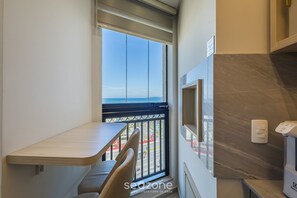 A balcony with a view of the city, a small table, and a chair. - Fully Equipped Apartments With a Prime Location 600 m From Itapema Beach Lprs (Itapema)