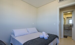 Ein Hotelzimmer mit Bett, einem durchgegangenen Tür erkennbaren Badezimmer und einem Fenster.